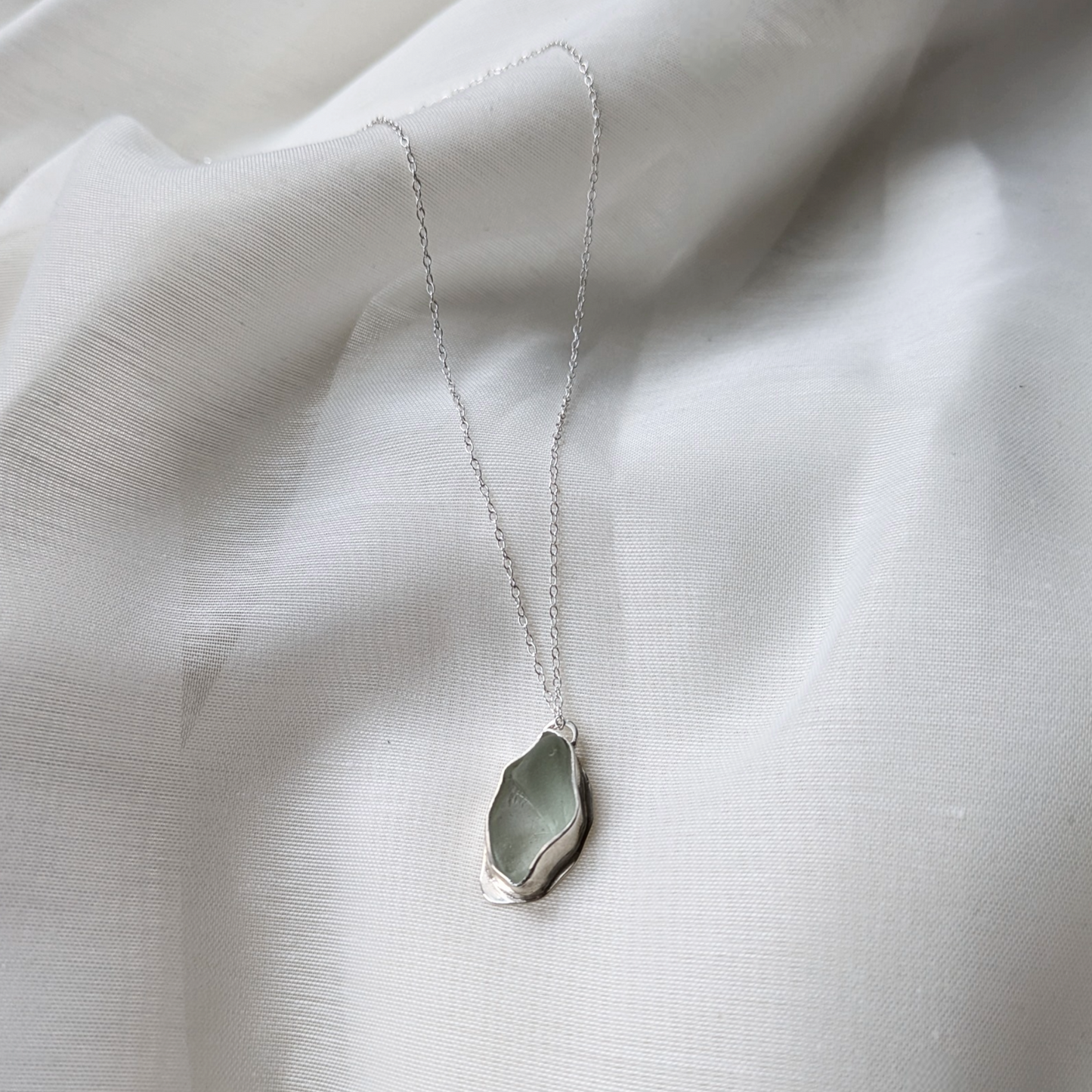 Turquoise sea glass necklace on white silk
