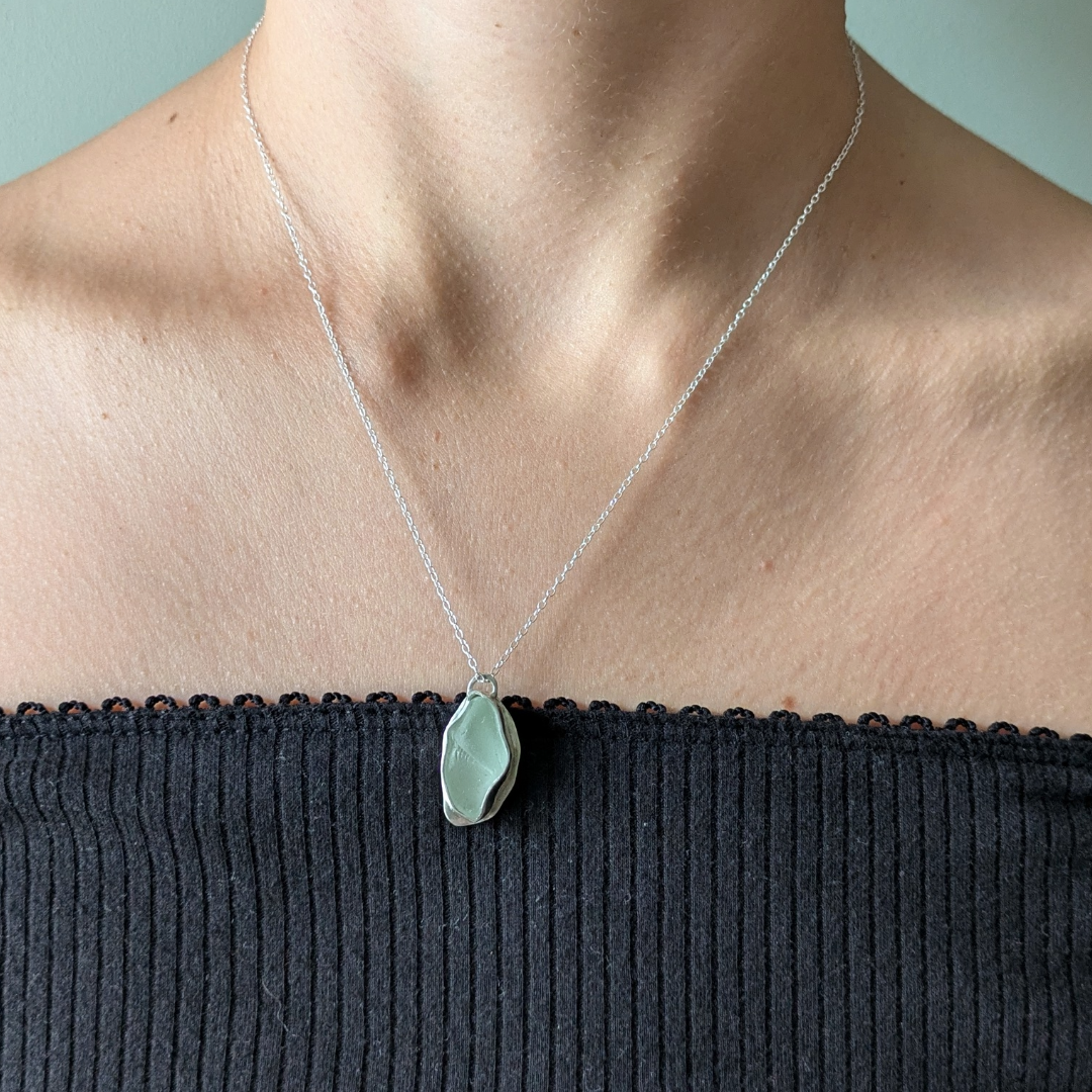 Close up of woman wearing blue sea glass pendant