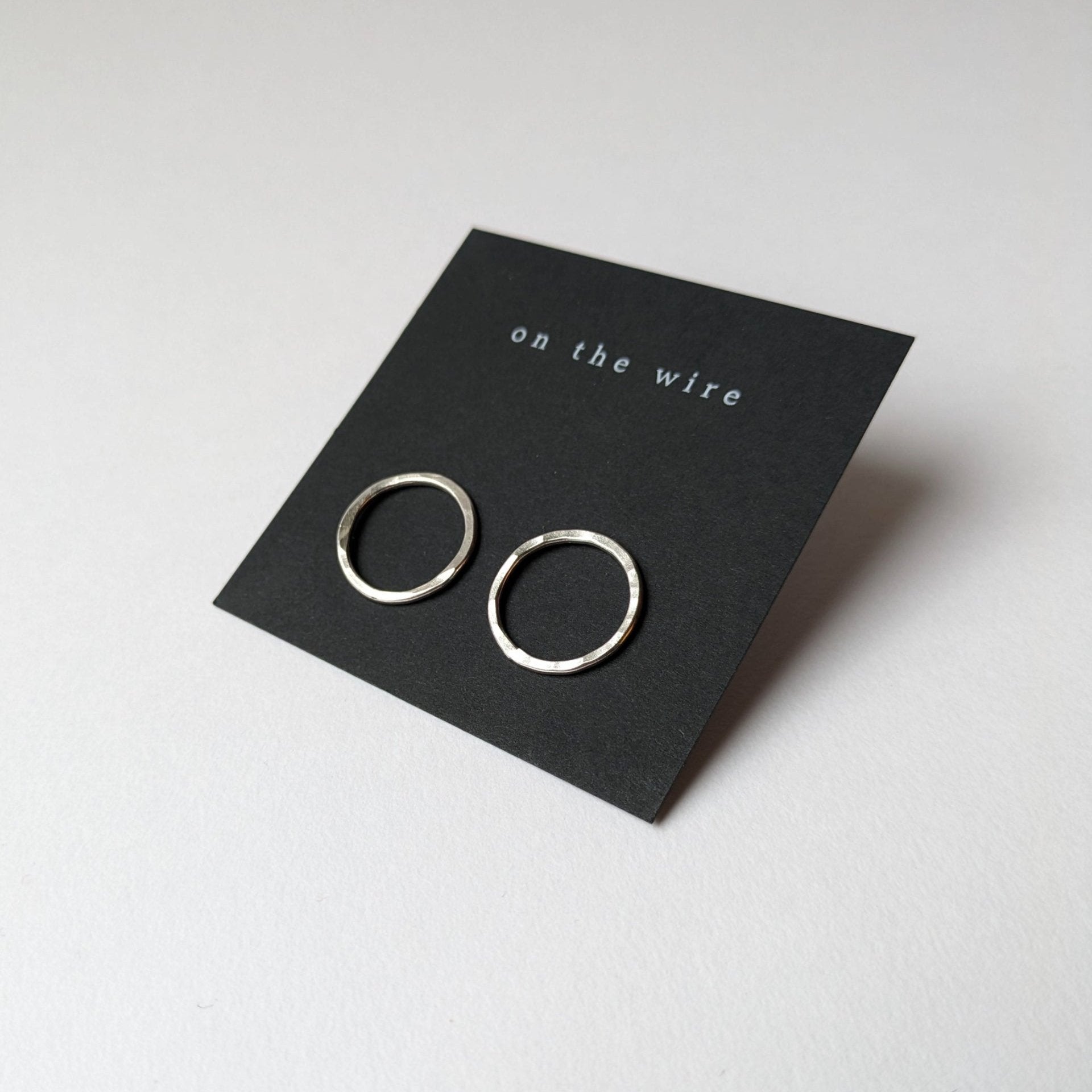 Big silver circle studs on black branded earring card
