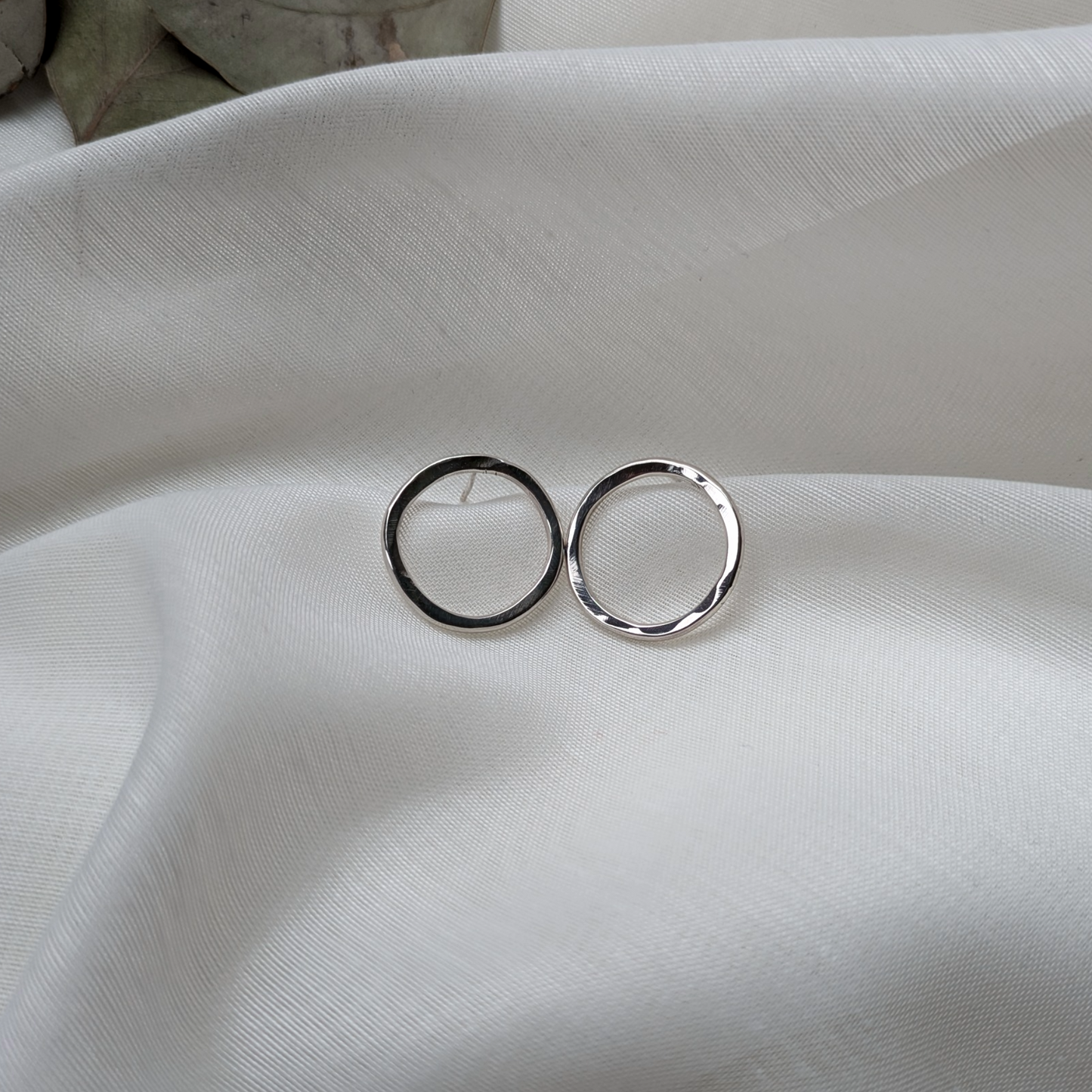 Big silver circle studs on white silk