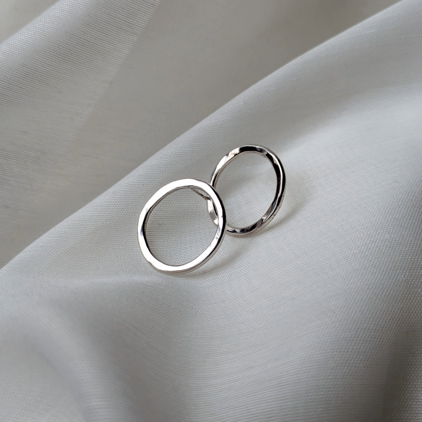 Big silver circle studs on white silk