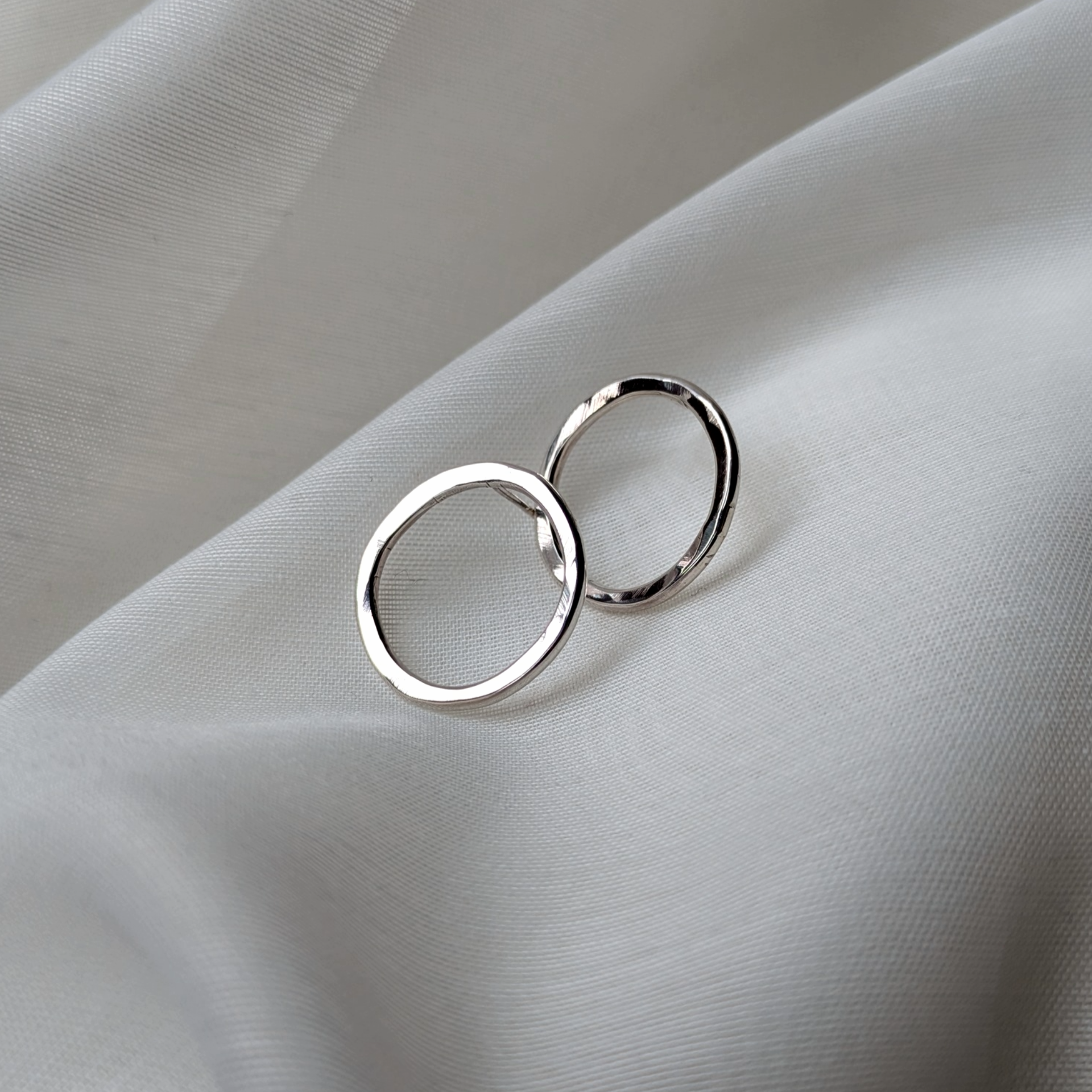 Big silver circle studs on white silk
