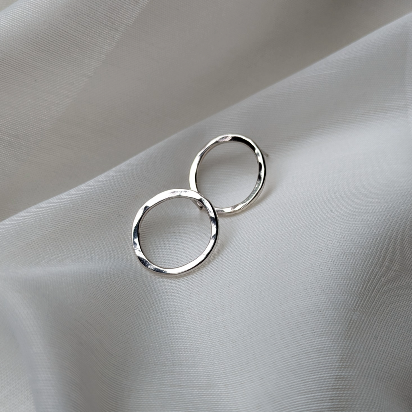 Big silver circle studs on white silk