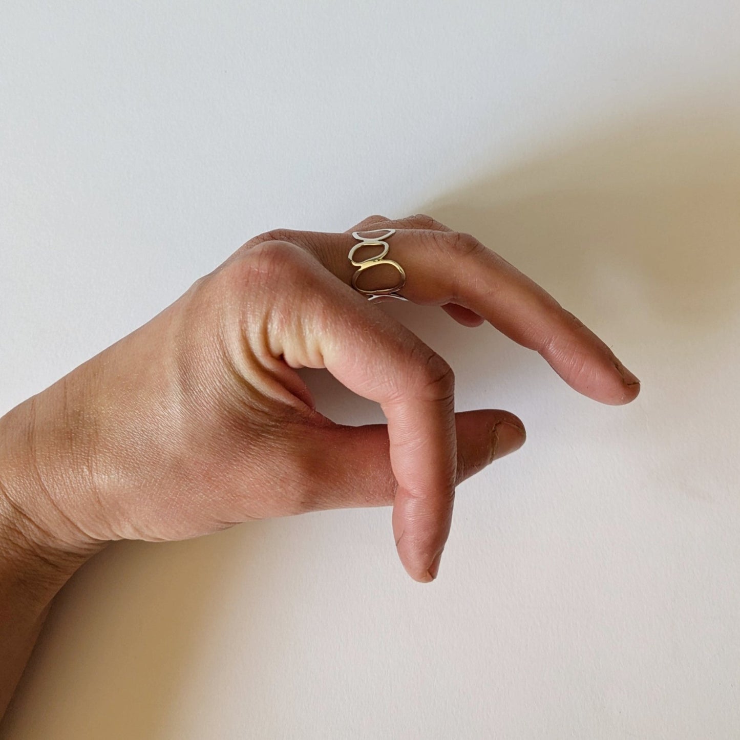 Silver Cairn ring on hand with white background