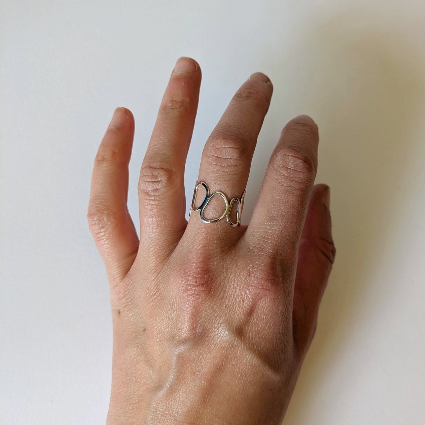 Silver Cairn ring on hand with white background