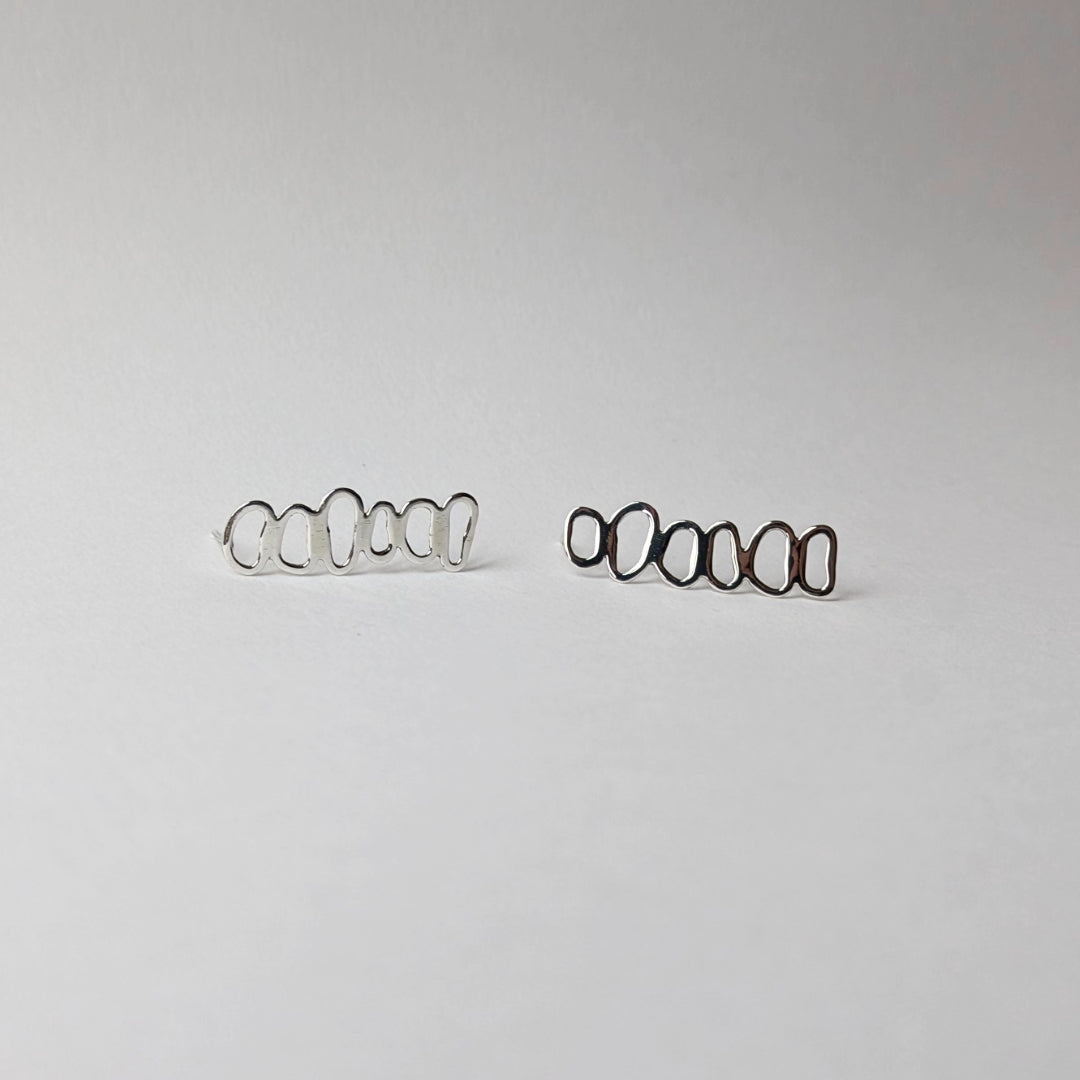 A pair of stacked pebble earrings horizontal on a white background