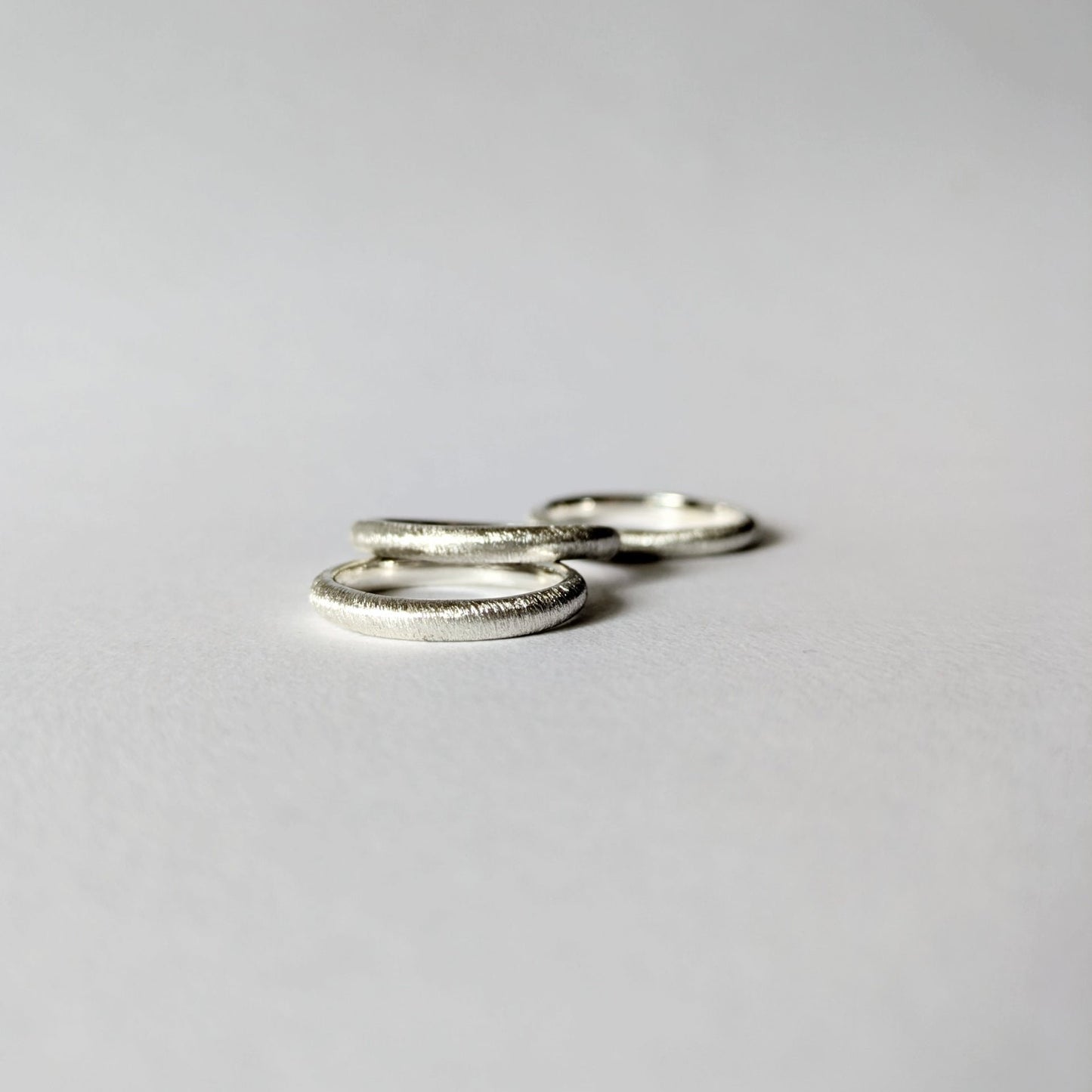 Close up of three d-shape rings in a pile on white background