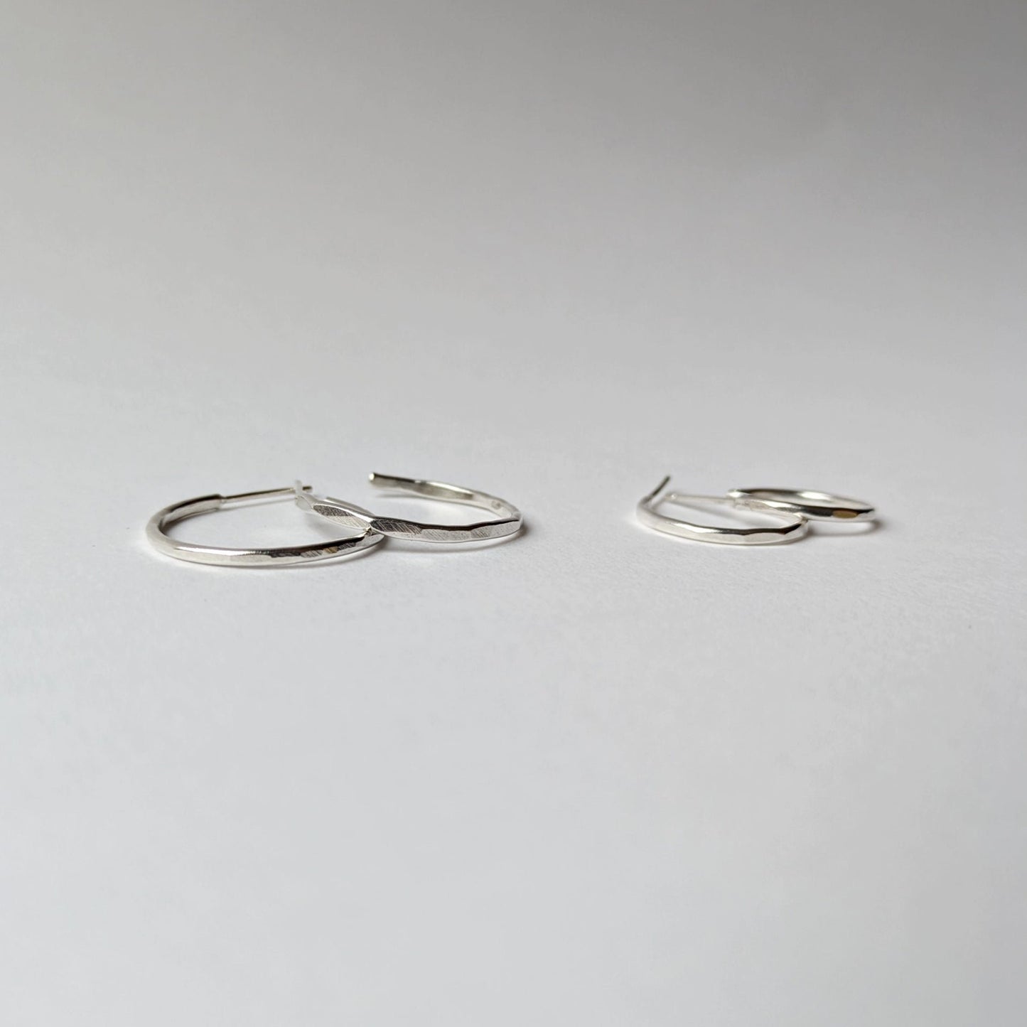 Small and medium hammered hoops on white background