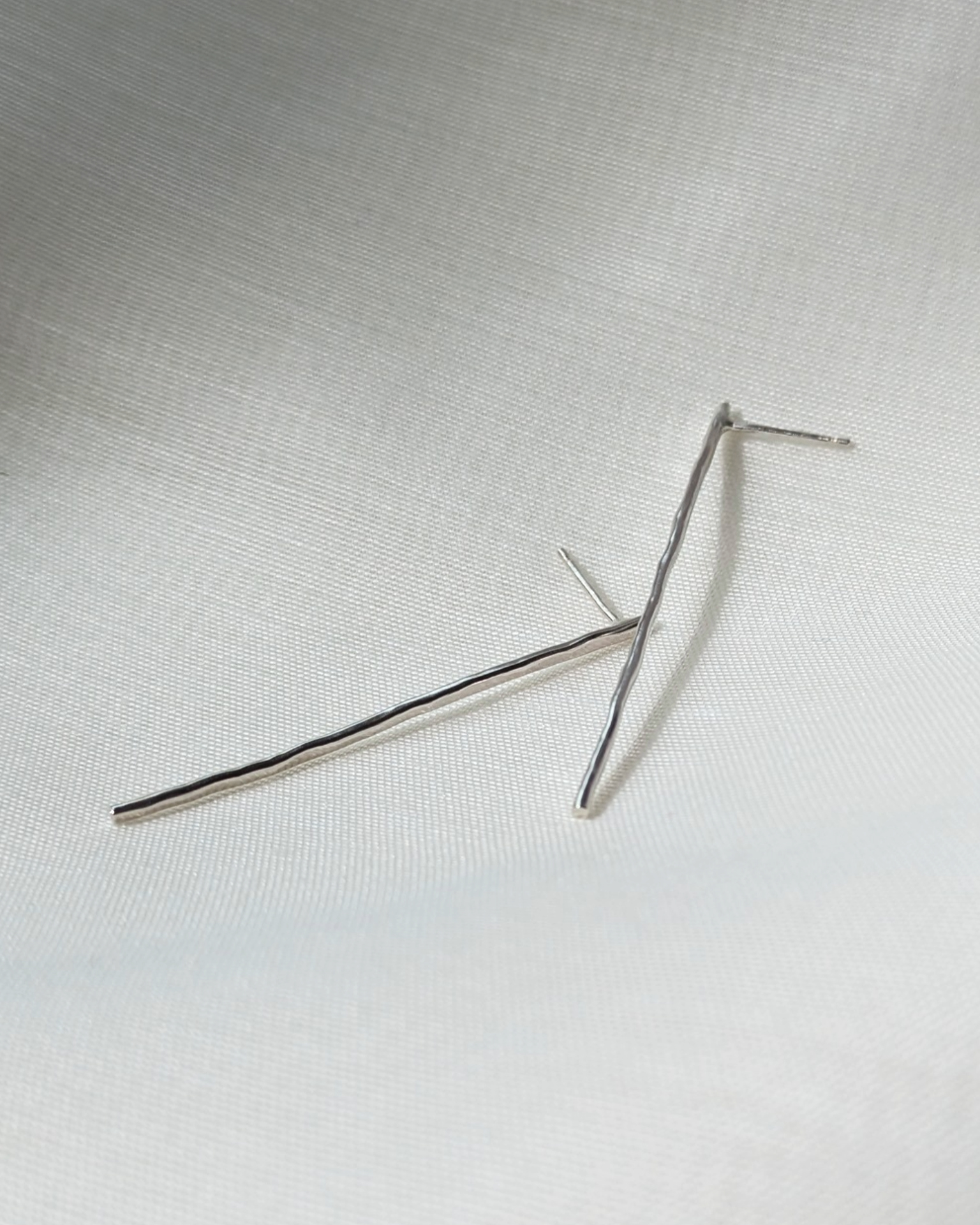 Hammered line studs on white silk