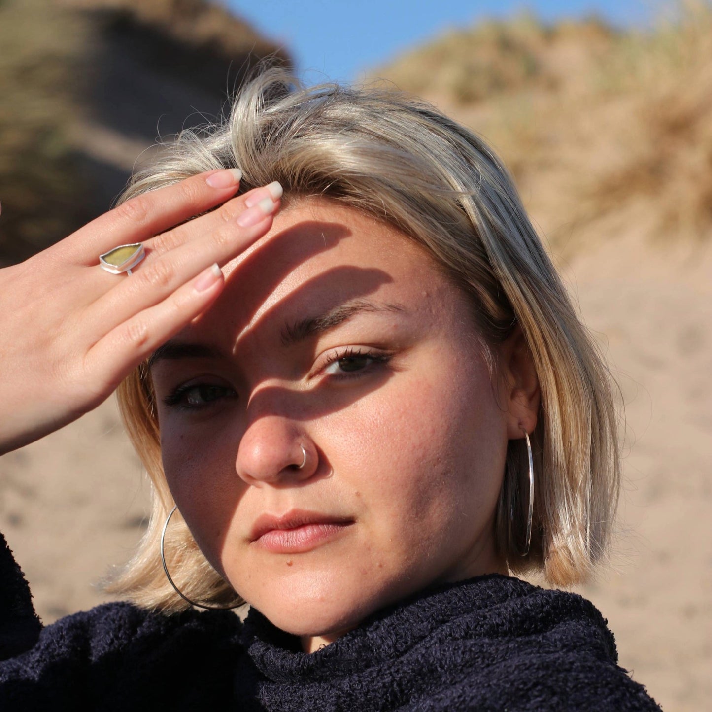 Woman on beach wearing green sea glass silver ring