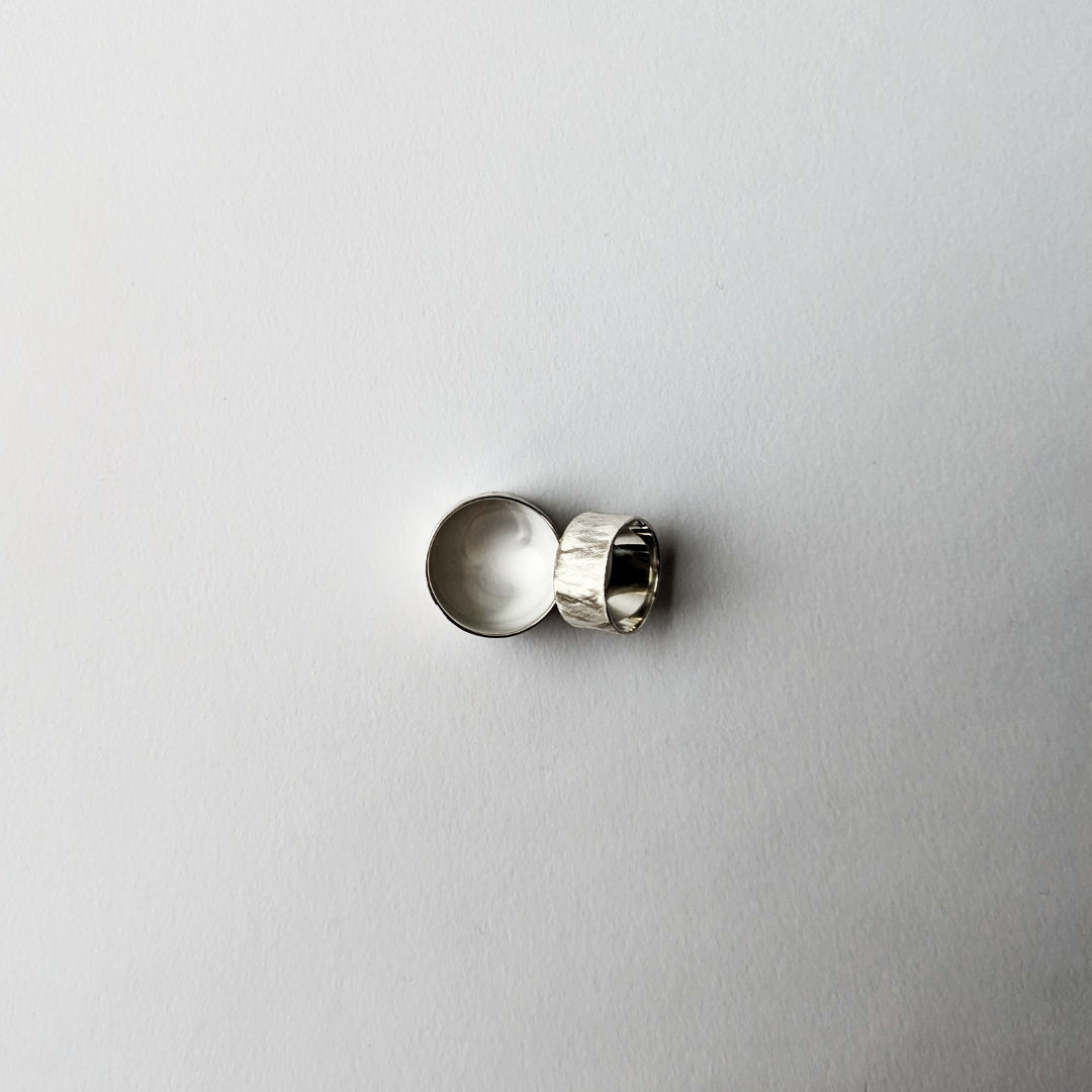 Wide and small feather textured silver rings on white background