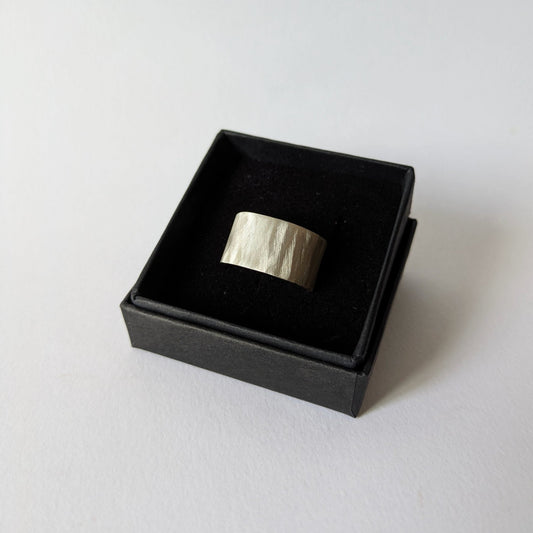 Feather texture silver ring in a black box on a white background