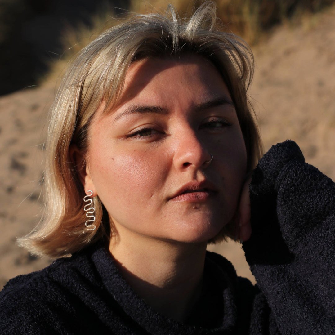 Woman wearing wiggle earrings on beach