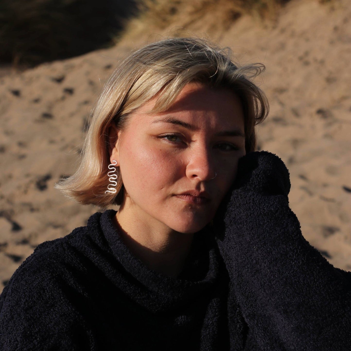 Woman wearing wiggle earrings on beach