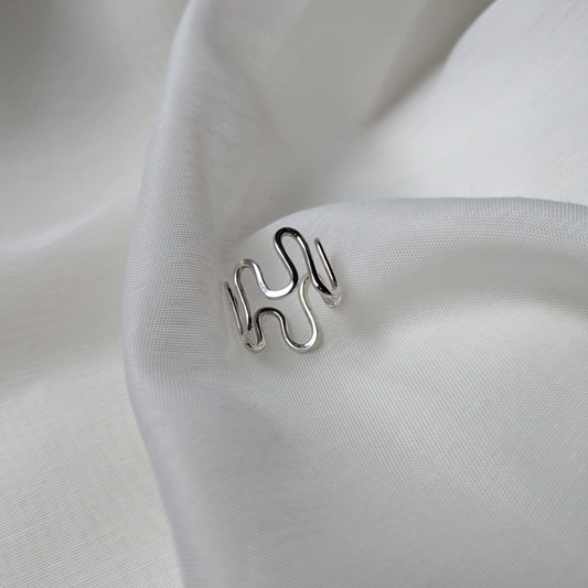 Silver wiggle ring on white silk