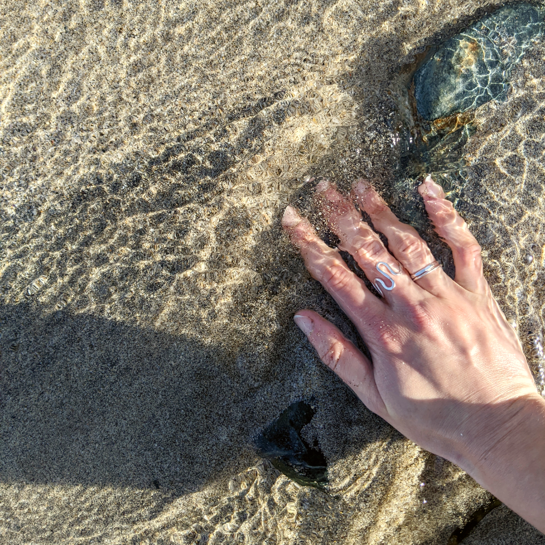Hand wearing wiggle ring in sea water