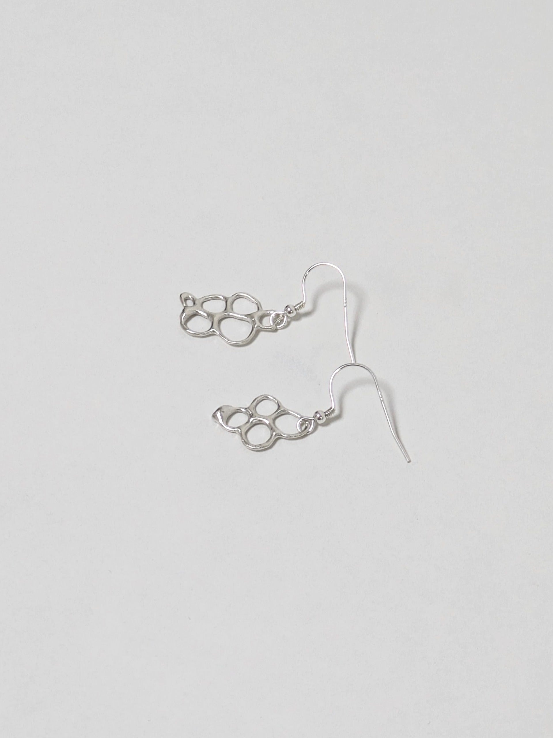 Organic shaped silver drop earrings on white background