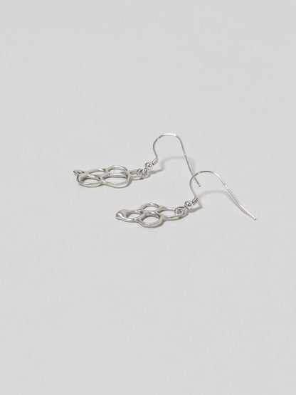 Side view of organic shaped silver drop earrings on white background