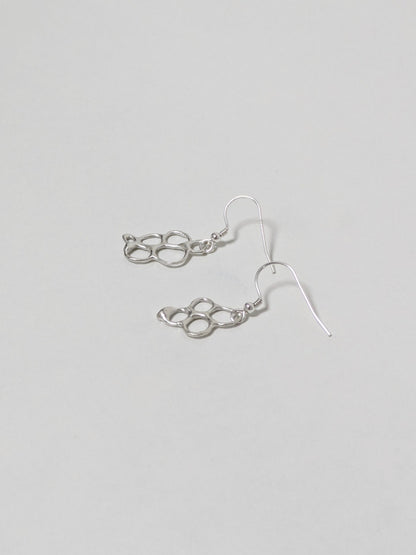 Organic shaped silver drop earrings on white background