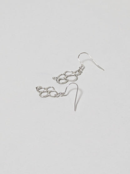 Organic shaped silver drop earrings on white background