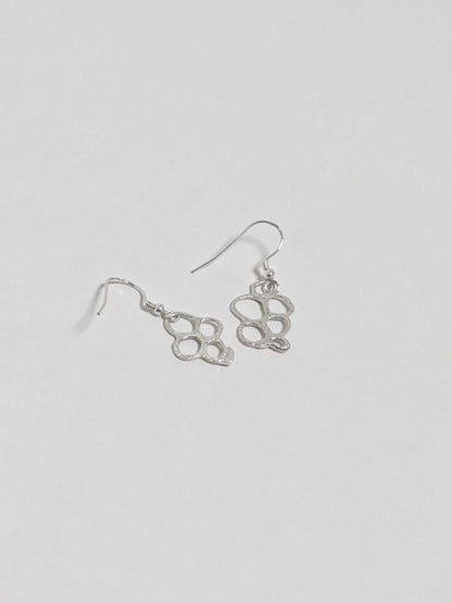 Back of organic shaped silver drop earrings on white background