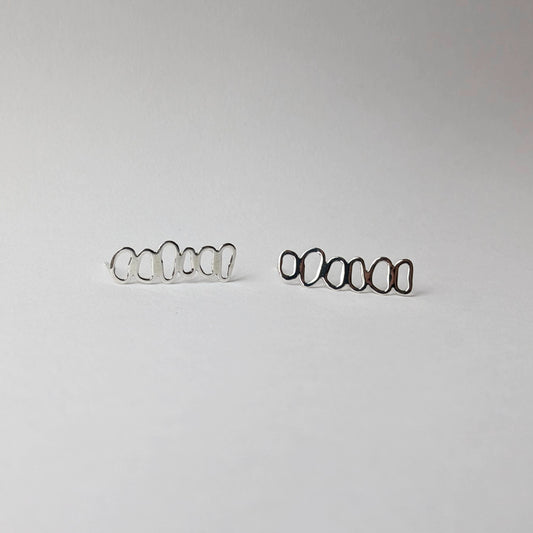 A pair of stacked pebble earrings horizontal on a white background