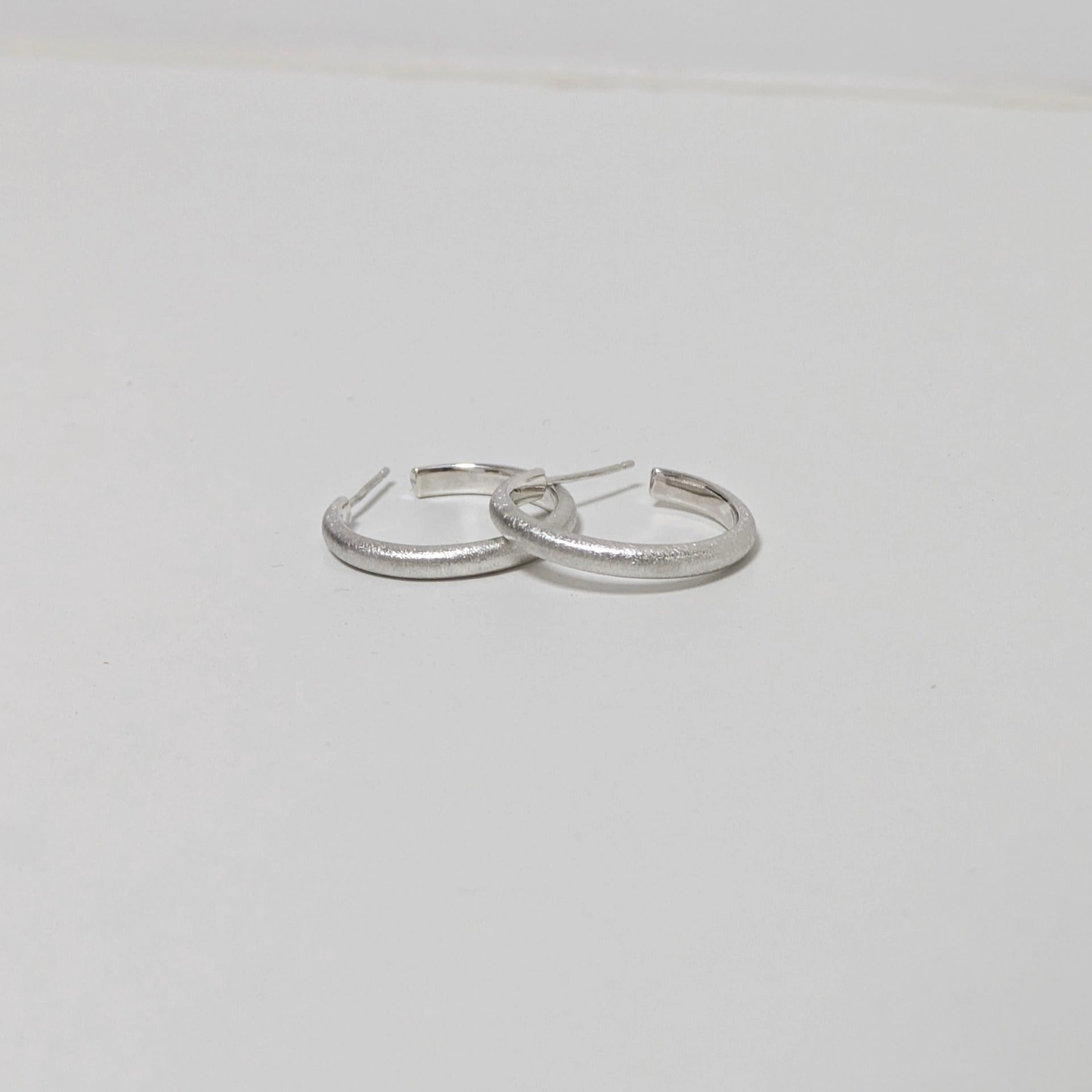 Two satin textured thin hoops on white background