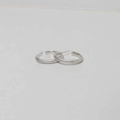 Two satin textured thin hoops on white background