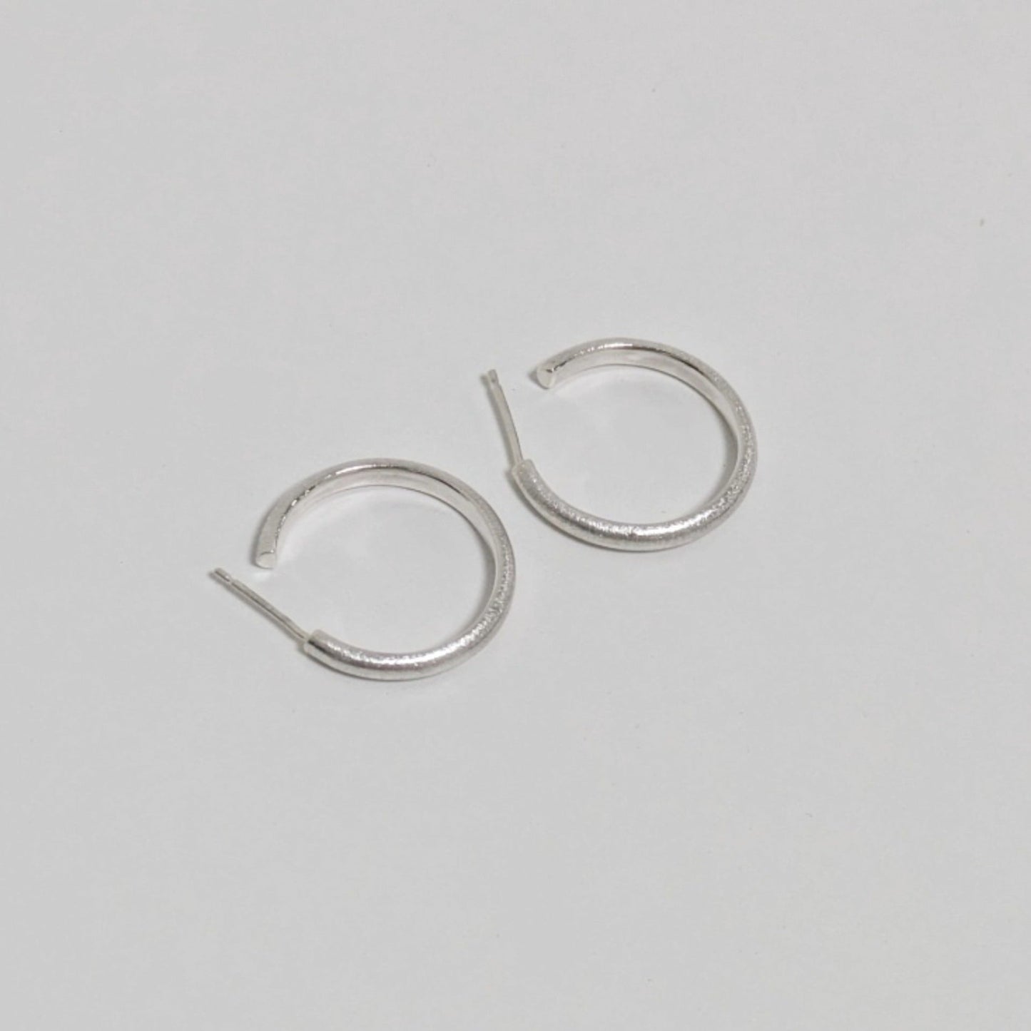 Two satin textured thin hoops on white background