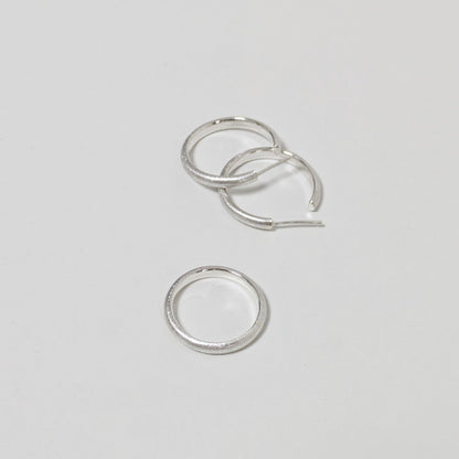 Two satin textured hoops and matching silver ring on white background