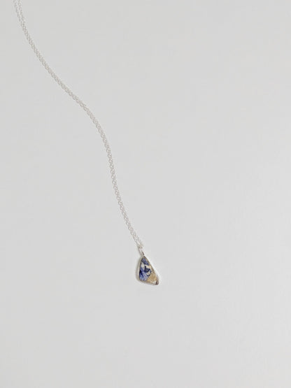 Mini blue and white sea pottery necklace on white background.