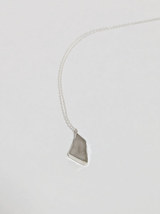 Necklace with a white sea glass pendant on a light gray background